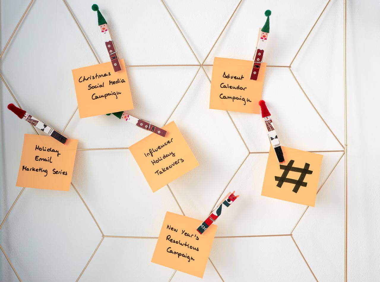 about-us-01 Sticky notes with holiday marketing ideas clipped to a wall grid.